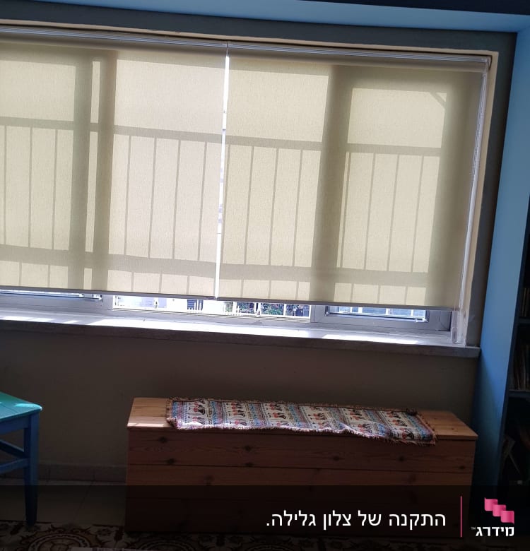 וילון גלילה בהיר על חלון גדול